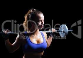 Female athlete with weights looking up against black background