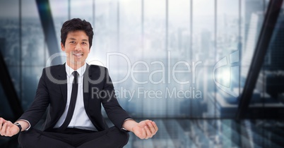 Business man meditating against dark blue blurry window