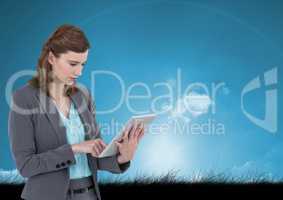 Woman on tablet with sky and grass background