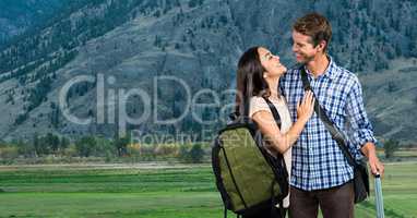 Smiling couple with bags traveling on mountains