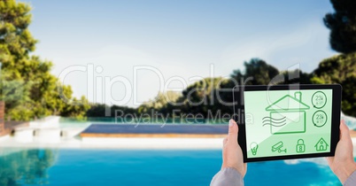 Cropped image of person using smart home app on tablet PC at poolside