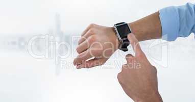 Hands with watch against blurry white skyline