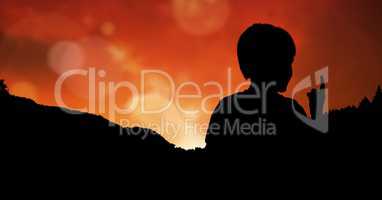 Silhouette of child pointing against sky during sunset