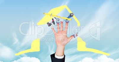 Digital composite image of hand with tools and house shape in sky