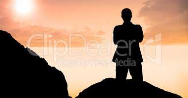 Silhouette businessman standing on mountain during sunset