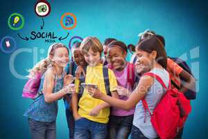 Digital composite image of school students looking at smart phone with various icons against blue ba