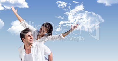 Happy man giving piggyback ride to woman against sky