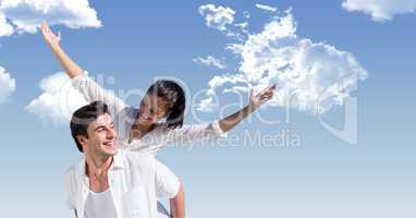 Happy man giving piggyback ride to woman against sky