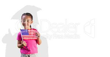 Digital composite image of girl holding American flag with graduate shadow in back