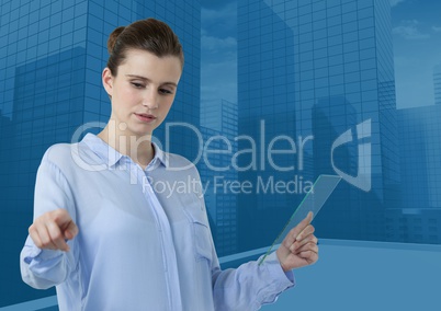 Woman touching air while holding glass tablet with blue city buildings background