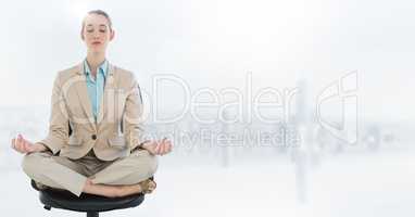 Business woman meditating on chair with flare against blurry white skyline