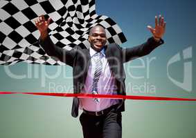 Business man reaching finish line against blue green background and checkered flag