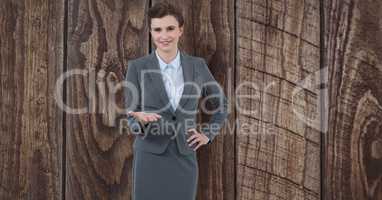 Businesswoman gesturing over wooden wall