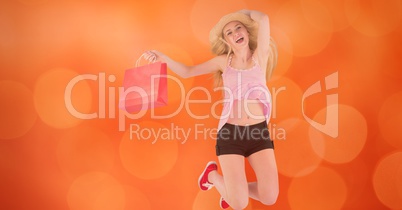 Happy woman with shopping bag jumping over bokeh