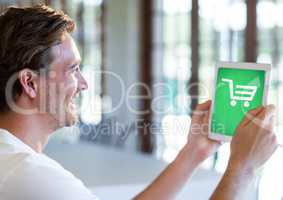 Man holding Tablet with Shopping trolley icon