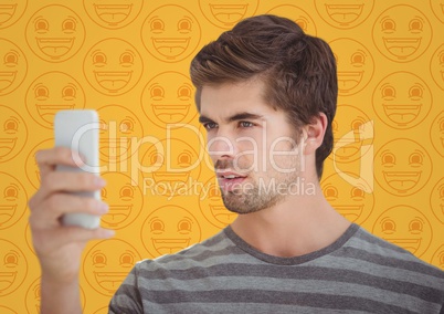 Man with phone against yellow emoji pattern