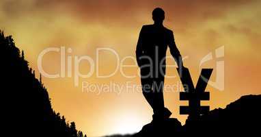 Silhouette businessman leaning on yen sign against orange sky