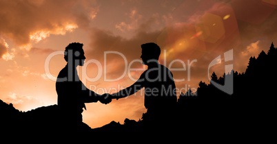 Silhouette businessmen shaking hands during sunset