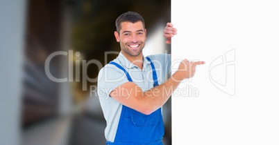 Portrait of smiling manual worker pointing at blank billboard
