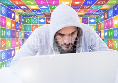 Man in hood on laptop in front of icons