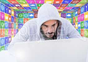 Man in hood on laptop in front of icons