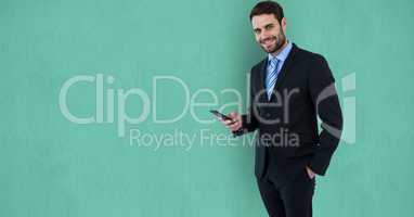 Confident businessman using mobile phone over green background