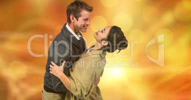 Romantic man embracing woman over blur background