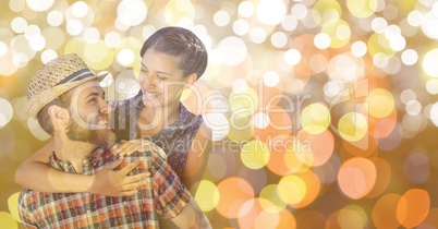 Happy man giving piggyback rise to woman over blur background