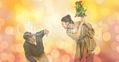 Angry woman hitting man with flowers over blur background