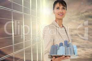 Composite image of woman holding buildings in 3d