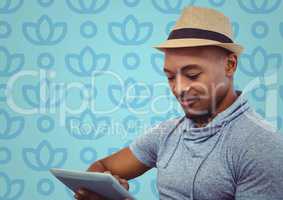 Man in fedora with tablet against blue floral pattern