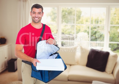 Happy deliveryman with the delivery bag and boxes in the livingroom