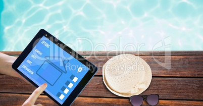 Hands using smart home application on tablet PC at poolside