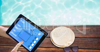Hands using smart home application on tablet PC at poolside