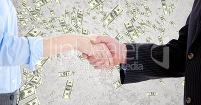 Midsection of business people shaking hands against banknotes