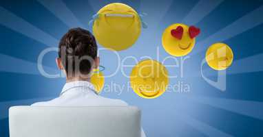 Digital composite image of businesswoman looking at emojis