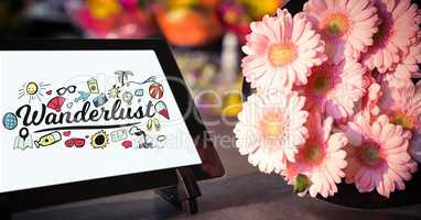 Close-up of wonderful text on device screen on tablet computer by flowers on table