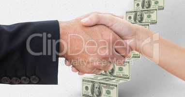 Close-up of handshake with money in background