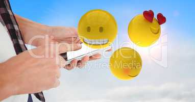 Midsection of business person using smart phone while emojis flying in sky
