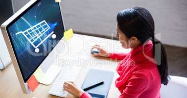 Businesswoman looking at shopping cart icon on computer