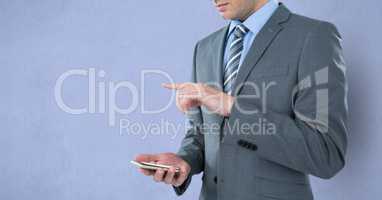 Midsection of businessman holding mobile phone while gesturing over purple background