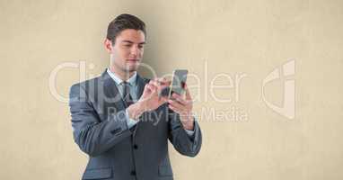 Handsome businessman using smart phone over beige background