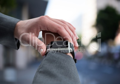 Hand with watch against blurry street