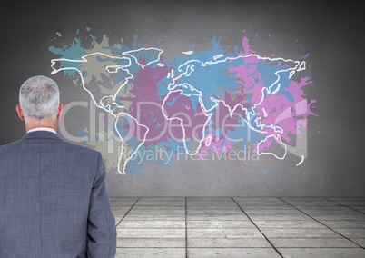 Businessman looking at Colorful Map with paint splattered wall background