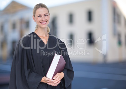 Judge holding book in front of building