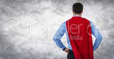 Back of business man superhero with hands on hips against white background and grunge overlay