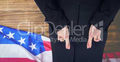 Rear view of businesswoman with fingers crossed against American flag