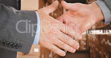 Business executives shaking hands in warehouse