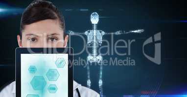 Portrait of doctor showing medical icons on tablet PC with skeleton in background