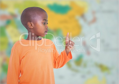 Boy pointing against blurry map